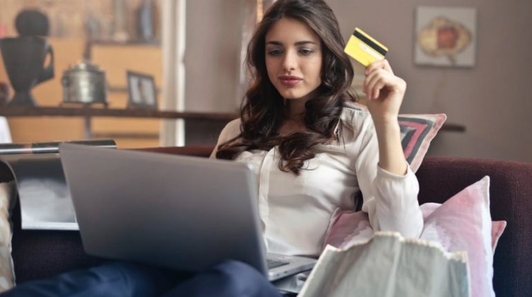 Une femme devant son ordinateur avec carte bancaire